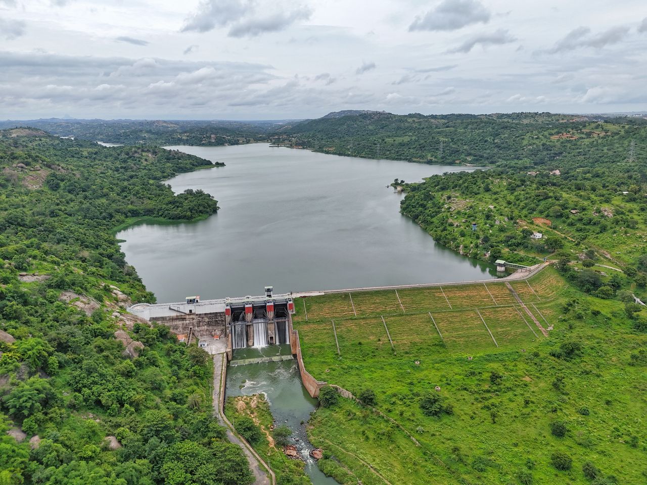 About Aerial shot of lush green landscape with a dam and reservoir in Bengaluru, India.
